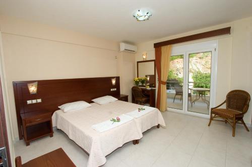 a bedroom with a large bed and a balcony at Hotel Viana in Loutra Edipsou