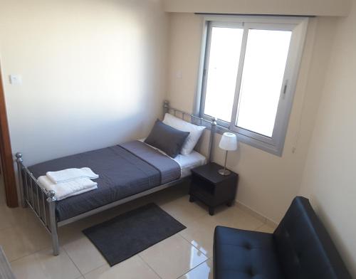 a small bedroom with a bed and a window at Lighthouse by the Sea Lovely 2Bdr Apartment in Paphos City
