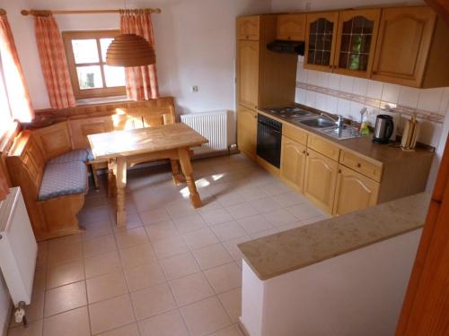 eine Küche mit einem Holztisch und einem kleinen Tisch sidx sidx sidx in der Unterkunft Ferienwohnung Baier in Bad Griesbach