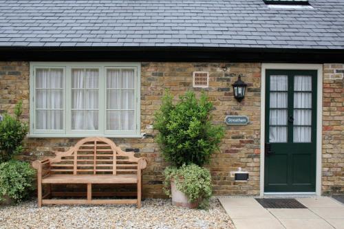 a wooden bench sitting outside of a brick house at The Woburn in Woburn