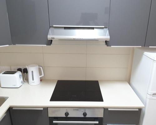 a small kitchen with a stove and a microwave at Lighthouse by the Sea Lovely 2Bdr Apartment in Paphos City