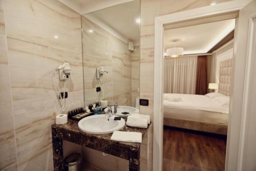 baño con lavabo y cama en Premium Beach Hotel, en Golem