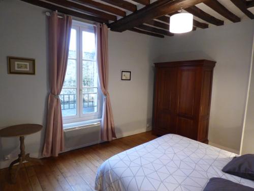 a bedroom with a bed and a window at Gîte de la cathédrale in Bayeux