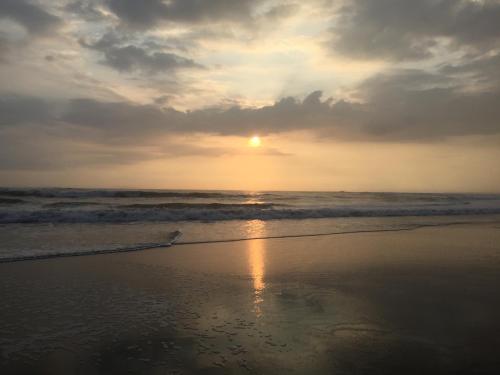 a sunset on a beach with the ocean at Balian Prana in Selemadeg