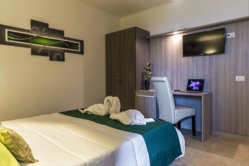 una camera da letto con un letto, una scrivania e una sedia di La Piazzetta Guest House a Olbia