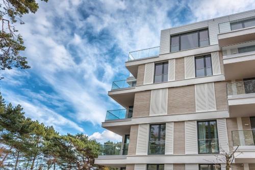 un edificio alto con un cielo azul en el fondo en Villa Vogue Gretas Beach Home en Binz