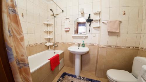 a bathroom with a sink and a tub and a toilet at Clean and comfortable apartments on Karl Marx street in Tiraspol