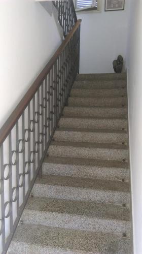 a stairway with a wooden rail and a stair case at Sweet Dream Rooms in Podgorica
