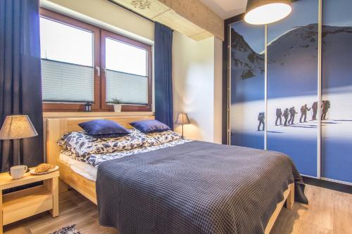 ザコパネにあるApartamenty Szymoszkowa Resort Ski Zakopaneのベッドルーム1室(青い壁と窓のあるベッド1台付)