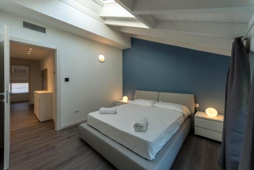 - une chambre avec un lit blanc et un mur bleu dans l'établissement Residenza Cece', à Lecco