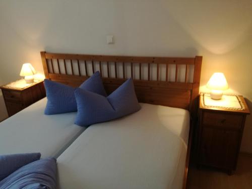 シュトゥンムにあるFerienwohnung Himlerのベッドルーム1室(青い枕のベッド1台付)