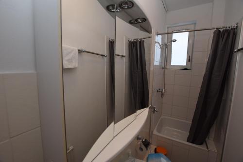 uma casa de banho com um chuveiro, um lavatório e uma banheira em Apartment Ostendplatz em Stuttgart