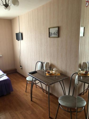 SarapulにあるGuest House on Gorkogoのテーブル、椅子、ベッドが備わる客室です。