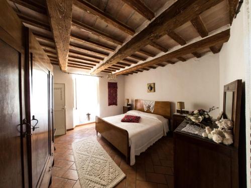 a bedroom with a bed in a room with wooden ceilings at Casa Di Mamma Casa Vacanze in Genga