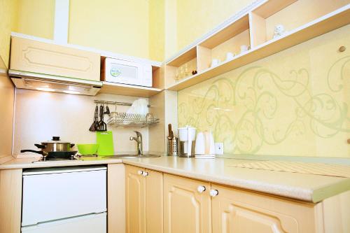 uma cozinha com armários brancos e uma bancada em Mini-Apartments on Sverdlova em Ecaterimburgo
