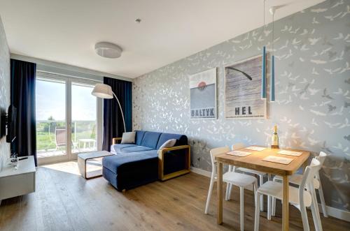 a living room with a blue couch and a table at Zacne Apartamenty in Jastarnia