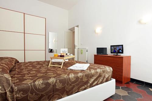 a bedroom with a bed and a table and a television at Angels In Rome in Rome