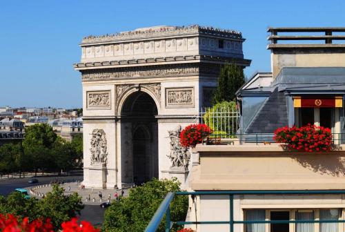 a building with an arch with red flowers on it at Hôtel Napoleon Paris in Paris