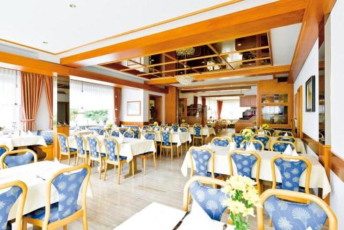 a restaurant with white tables and blue chairs at Hotel Gasthof Rössle in Rottenburg