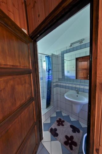 a bathroom with a sink and a toilet and a door at Camping KamA in Mikołajki