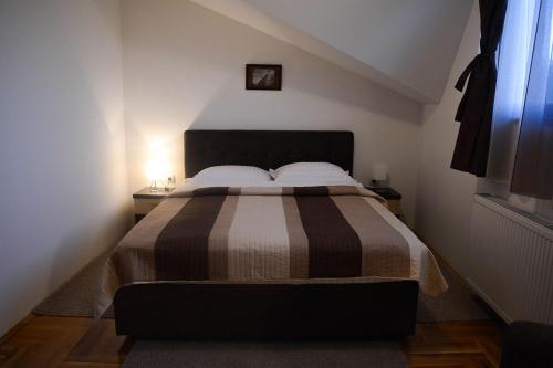 a bedroom with a bed with a brown and white blanket at Royal Apartments in Smederevo