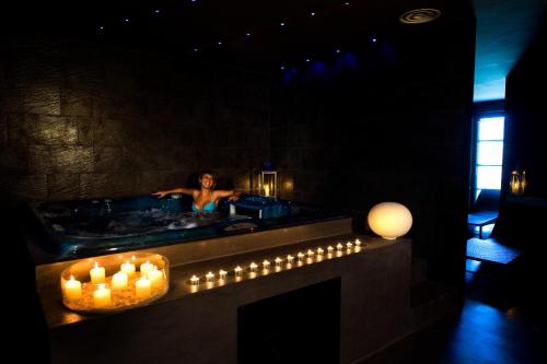 a woman in a bath tub with candles in it at La Reggia Sporting Center Hotel in Cascia