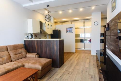 ein Wohnzimmer mit einem Sofa und einer Küche in der Unterkunft Boulevard apartment in Batumi