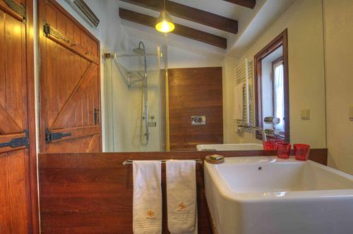 a bathroom with a sink and a shower with towels at Herdade Do Touril in Zambujeira do Mar