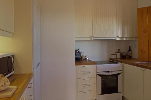 a kitchen with white cabinets and a stove top oven at Herdade Do Touril in Zambujeira do Mar