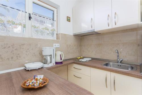 een keuken met een wastafel en een kom snoep bij Apartmani LuNa in Hvar