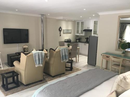 a living room with a couch and a kitchen at Meraki Country Manor in Lanseria