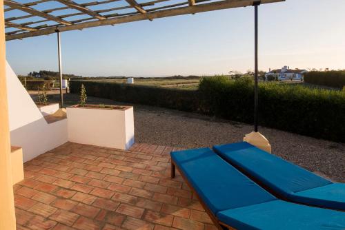 a blue couch sitting on a brick patio at Herdade Do Touril in Zambujeira do Mar