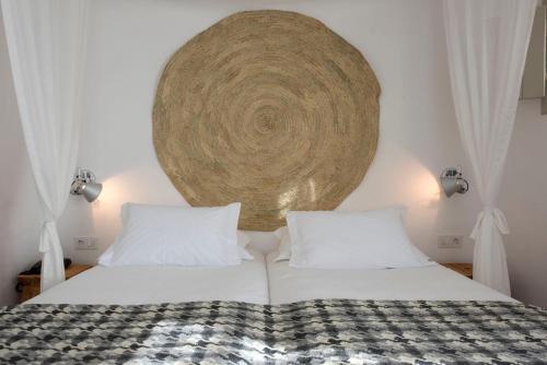 a bed with two white pillows and a large wall at Herdade Do Touril in Zambujeira do Mar