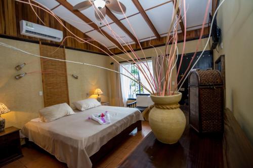 a bedroom with a bed and a large vase at Pacific Paradise Resort in Quepos