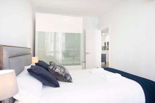 a bedroom with a white bed with blue pillows at Apartment Alcala 146 in Madrid