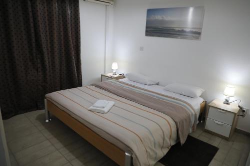 um quarto com uma cama grande e 2 mesas de cabeceira em Bianco E U Apartment em Nicósia