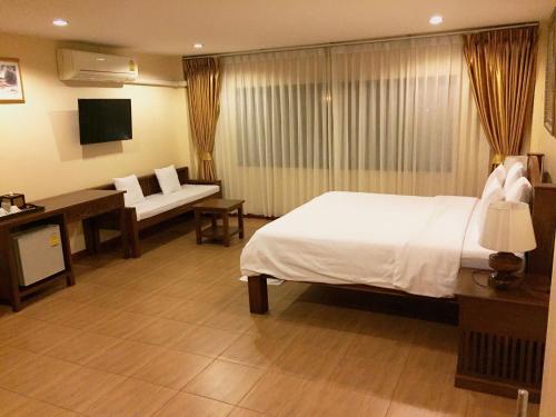 a hotel room with a large bed and a desk at Chan Chiangmai House in Chiang Mai