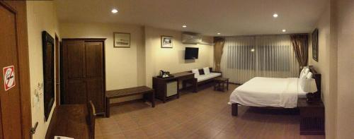 a hotel room with a bed and a desk at Chan Chiangmai House in Chiang Mai