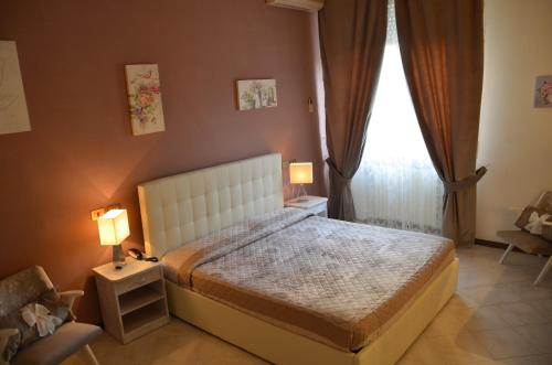 a bedroom with a bed and two lamps and a window at Hotel President in Chianciano Terme