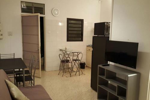 聖克羅蒂德的住宿－Appartement Centre Sainte-Clotilde，带电视的客厅和带桌子的厨房