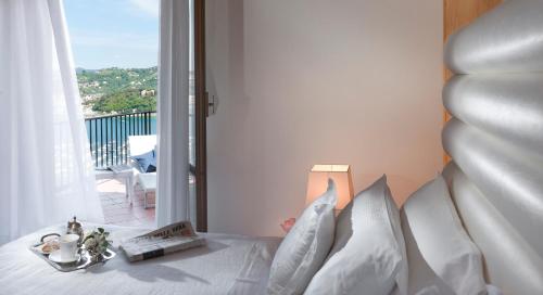 a bedroom with a bed with white sheets and a window at Europa Grand Hotel in Lerici