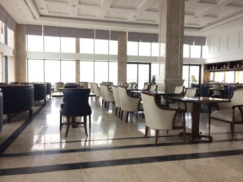 una sala da pranzo con tavoli, sedie e finestre di Beachfront Luxury Apartment in Altara Building - Da Nang a Da Nang