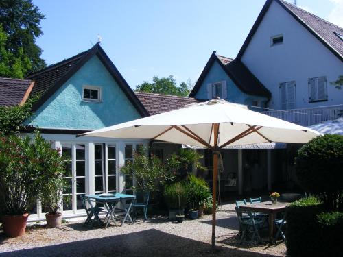 an umbrella in the courtyard of a house at Am Eichholz Galerie & Art-Hotel in Murnau am Staffelsee