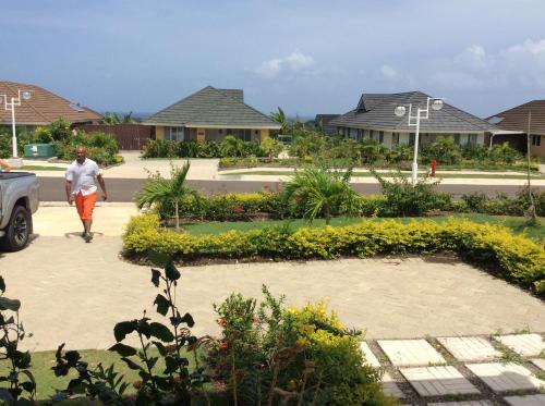 a man walking down a sidewalk in front of some houses at Richmond - Heroes Villa, AC, Security, Access to Pool, Playground & Private Beach - Welcome Breakfast Basket in Richmond