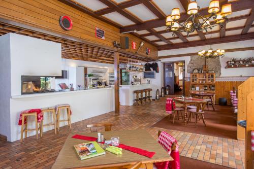 um restaurante com mesas e cadeiras e um bar em Alpenhaus Kesselfall, Zell am See - Kaprun Sommercard included em Kaprun