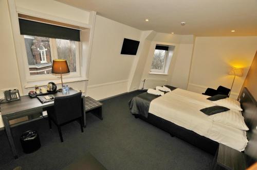 a hotel room with a bed and a desk and a desk at Hotel Parkview in Amsterdam