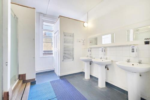 a bathroom with two sinks and a window at Hootananny Hostel in London