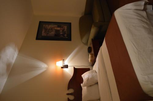 a bedroom with two beds and a light on the wall at Hotel Port Aux Basques in Channel-Port aux Basques