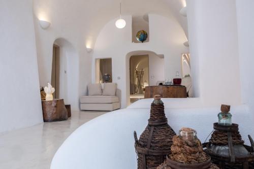 a white room with a bed and a couch at The Globe Suites Villa in Fira