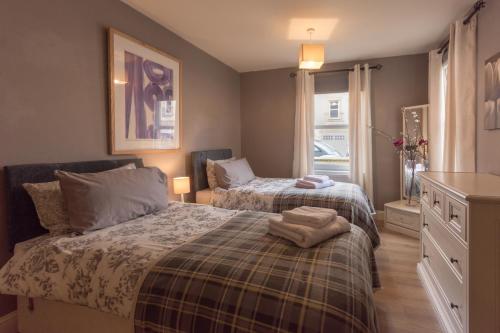 a bedroom with two beds and a window at Marina View Apartment in Inverkip